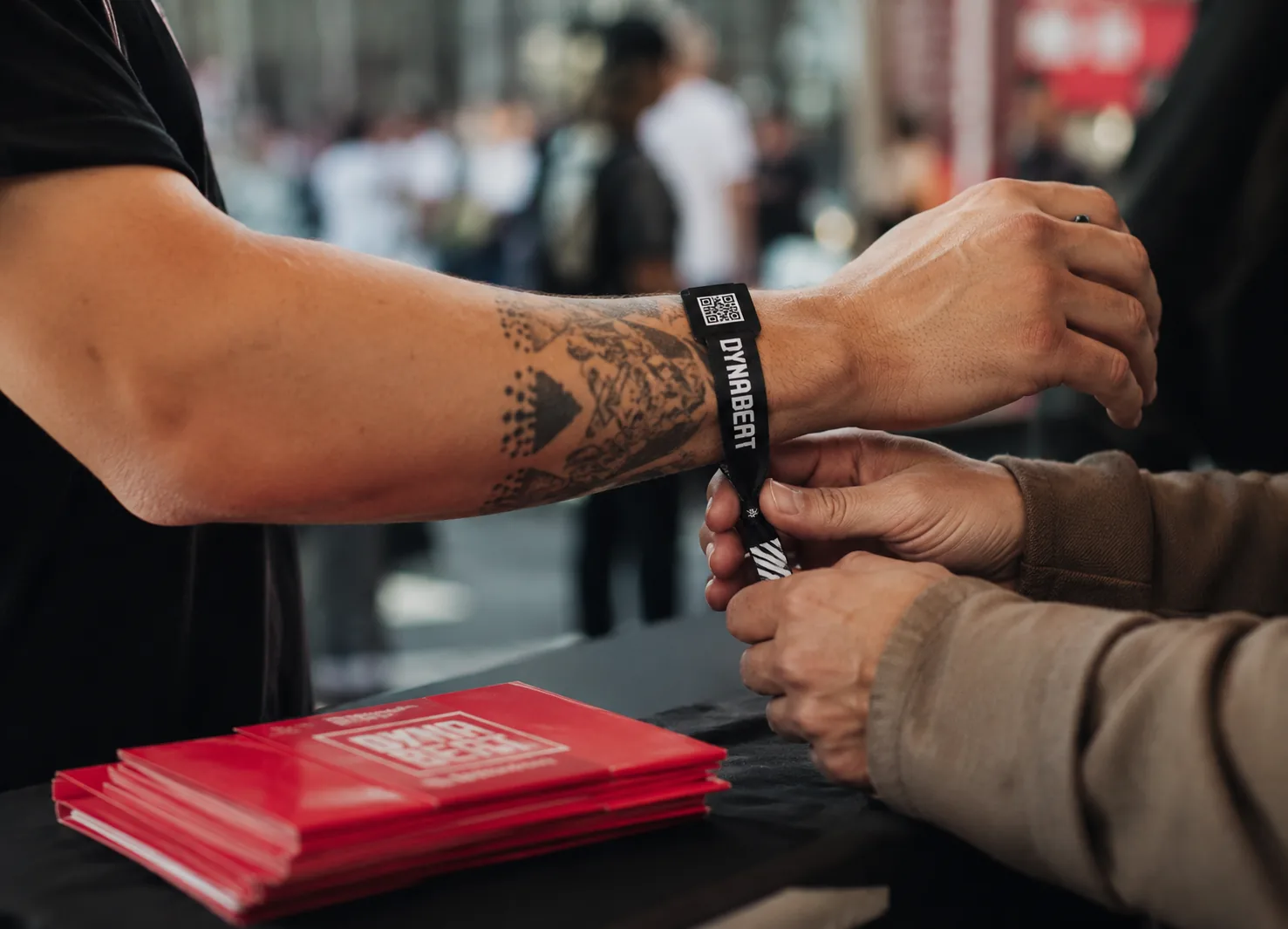 DYNABEAT Festival-Armband mit QR-Code wird einem Gast am Eingang angelegt